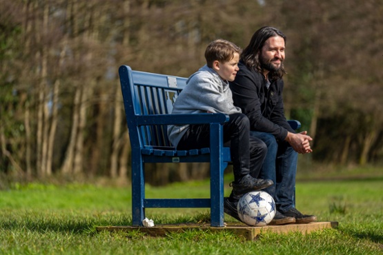a man and a boy sat on a bench