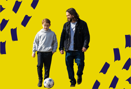 A man and a child kicking a football