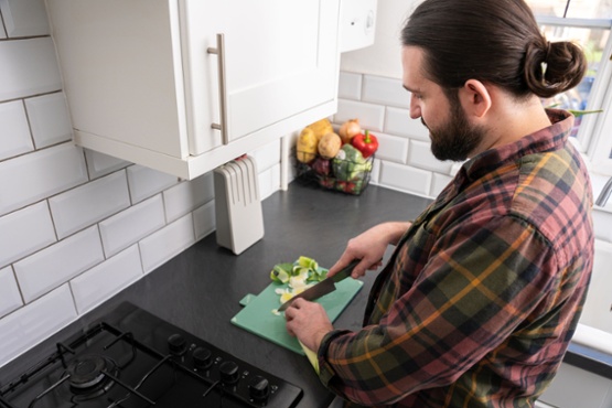 A man cutting vegetables in a kitchen
