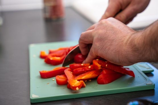 Someone cutting red peppers