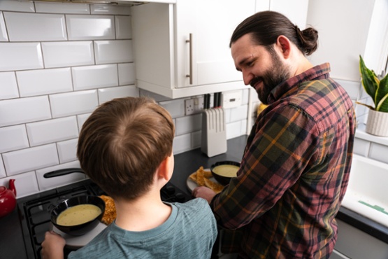 A man and a boy with bowls of soup